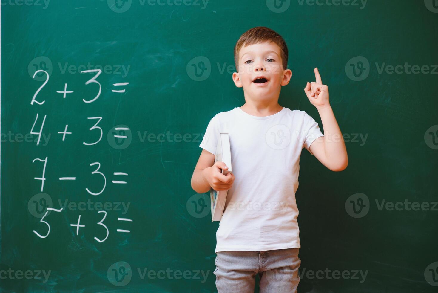 Back to school concept. School child in class. Happy kid against green blackboard. Smart child in classroom. Idea and education concept photo