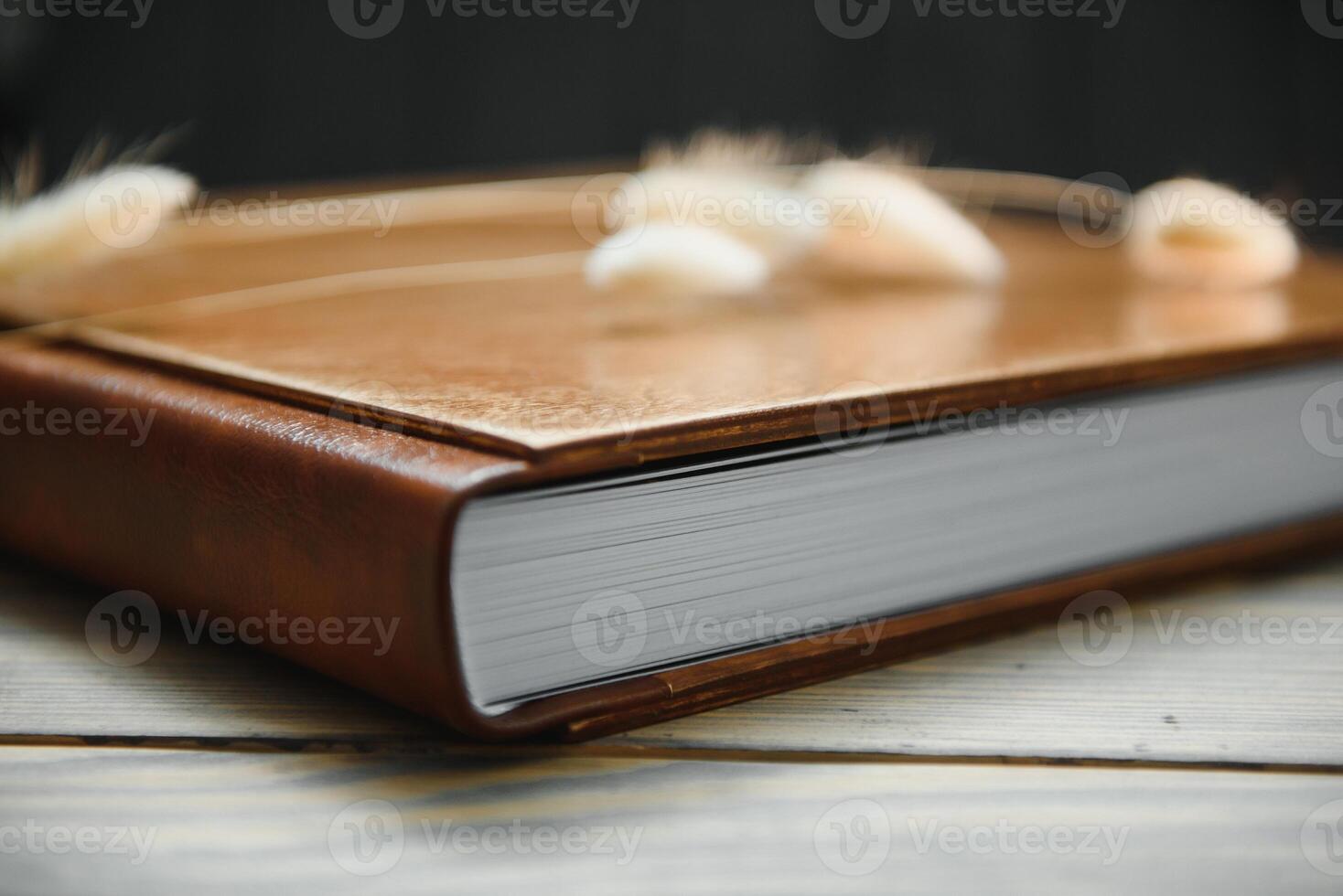 Family photo book with embossing. Photo book on a wooden background. Brown photo book with wood cover. Photoalbum with a hard cover. Wedding photo album.