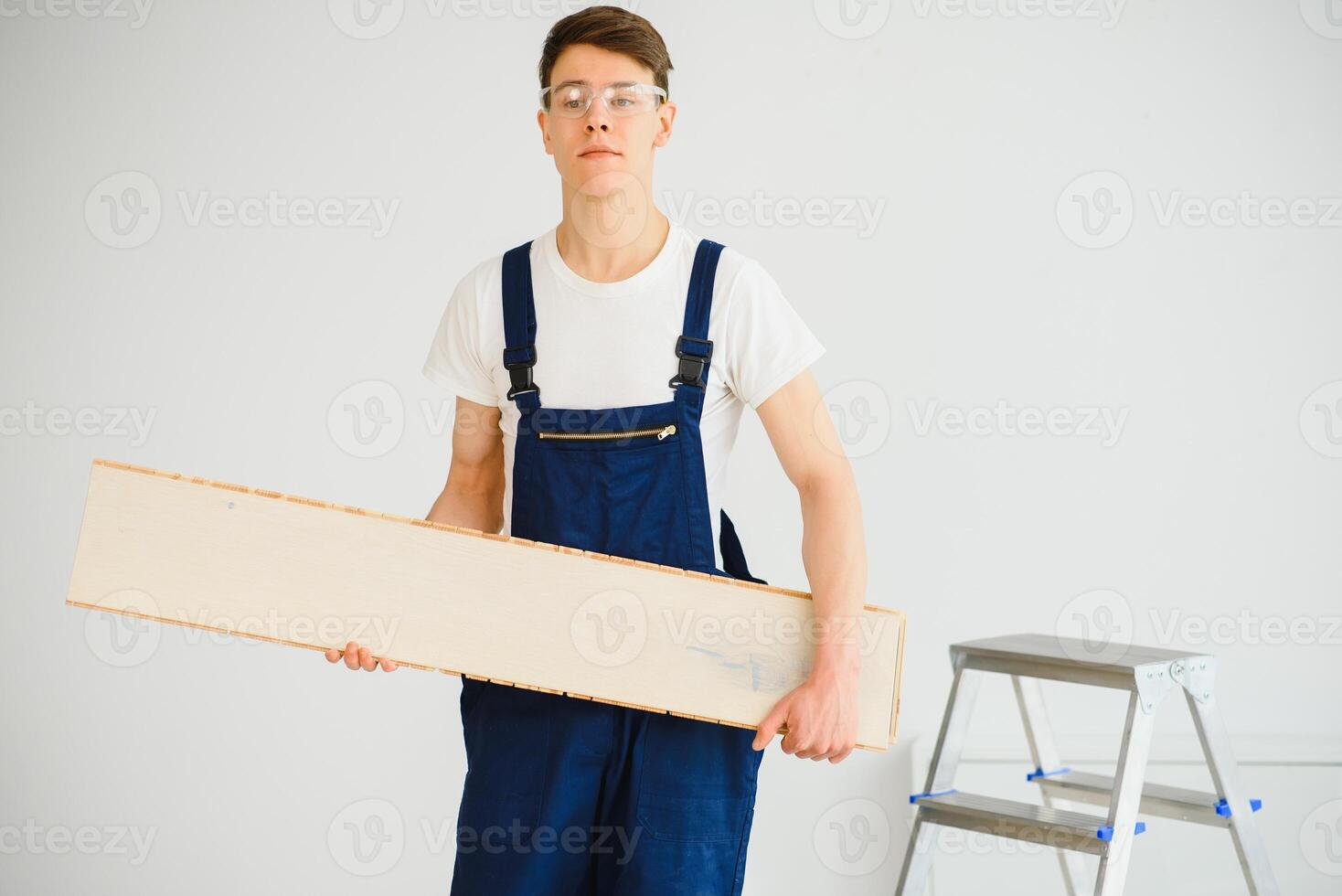 Worker with materials for installing laminate flooring photo