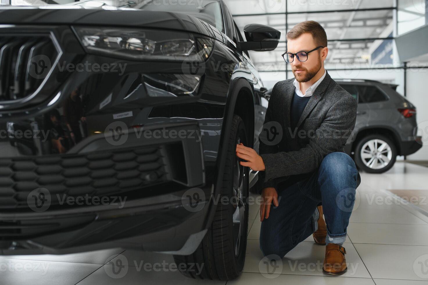 Man adult customer male buyer client wears classic suit white shirt chooses auto wants to buy new automobile touch check car in showroom vehicle salon dealership store motor show indoor. Sales concept photo