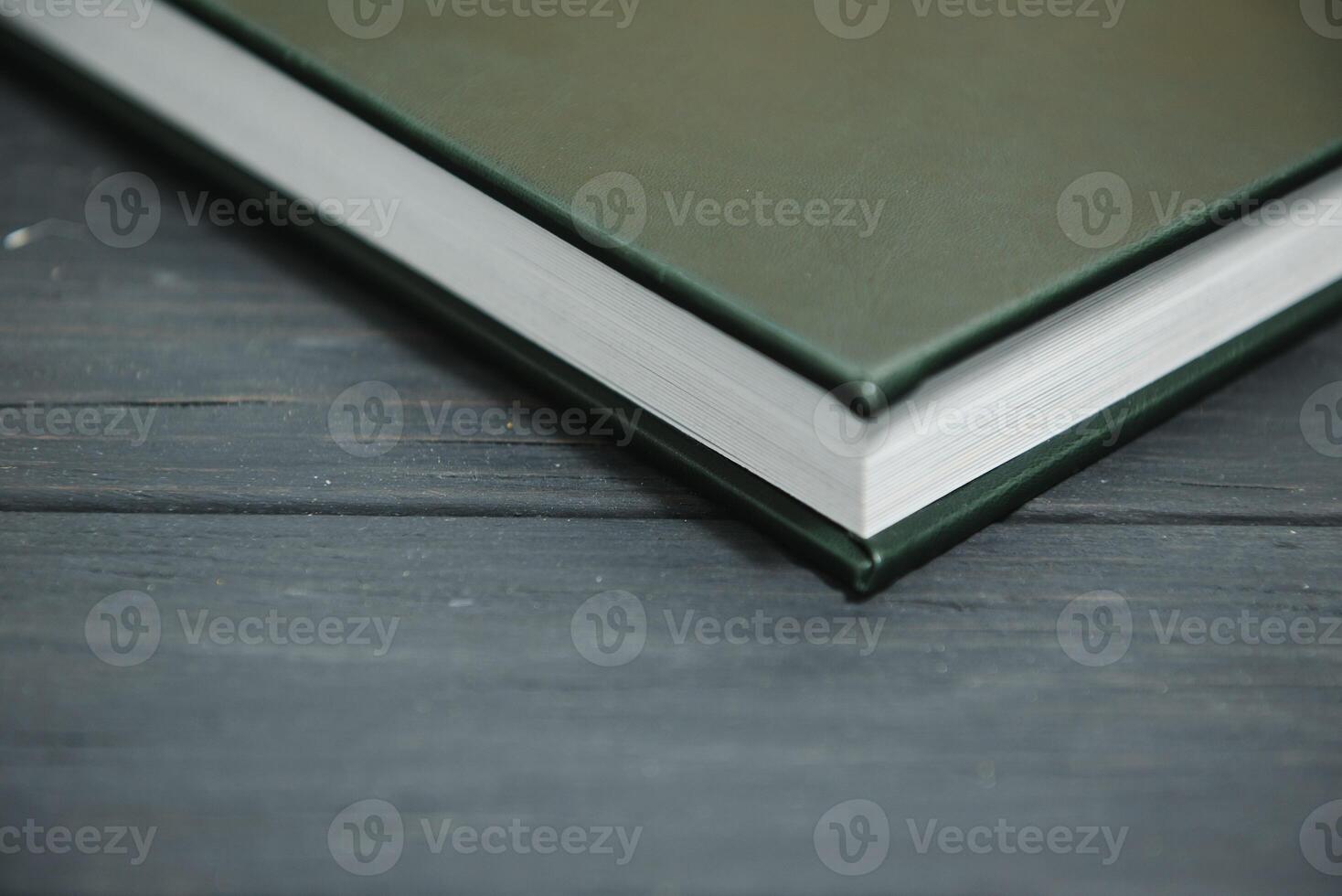Green wedding or family photo book with leather cover. stylish wedding photo album close up. family photoalbum on wooden background.
