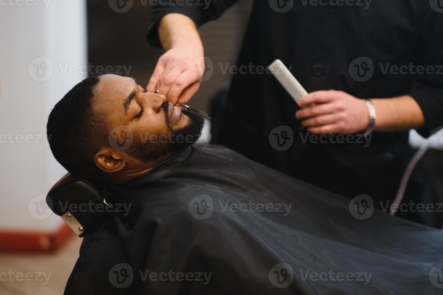 Young African-american man visiting barbershop photo