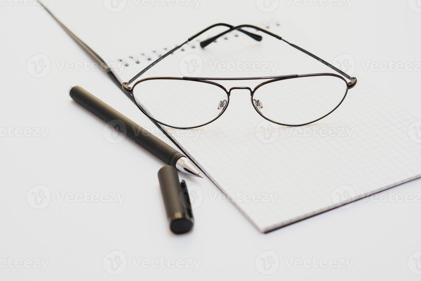 opened notebook with pen and glasses isolated photo