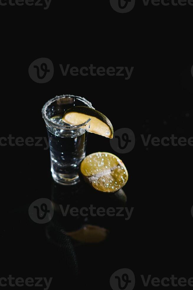 tequila with lime on a dark background photo