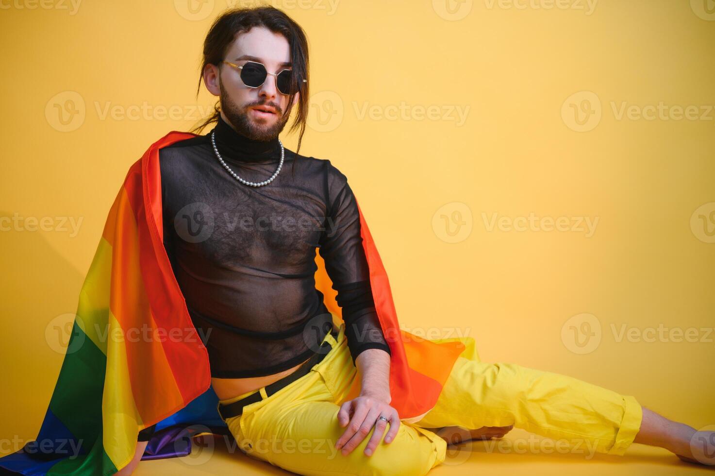 joven, hermoso gay hombre en un de colores antecedentes en el estudio. lgbt concepto. foto