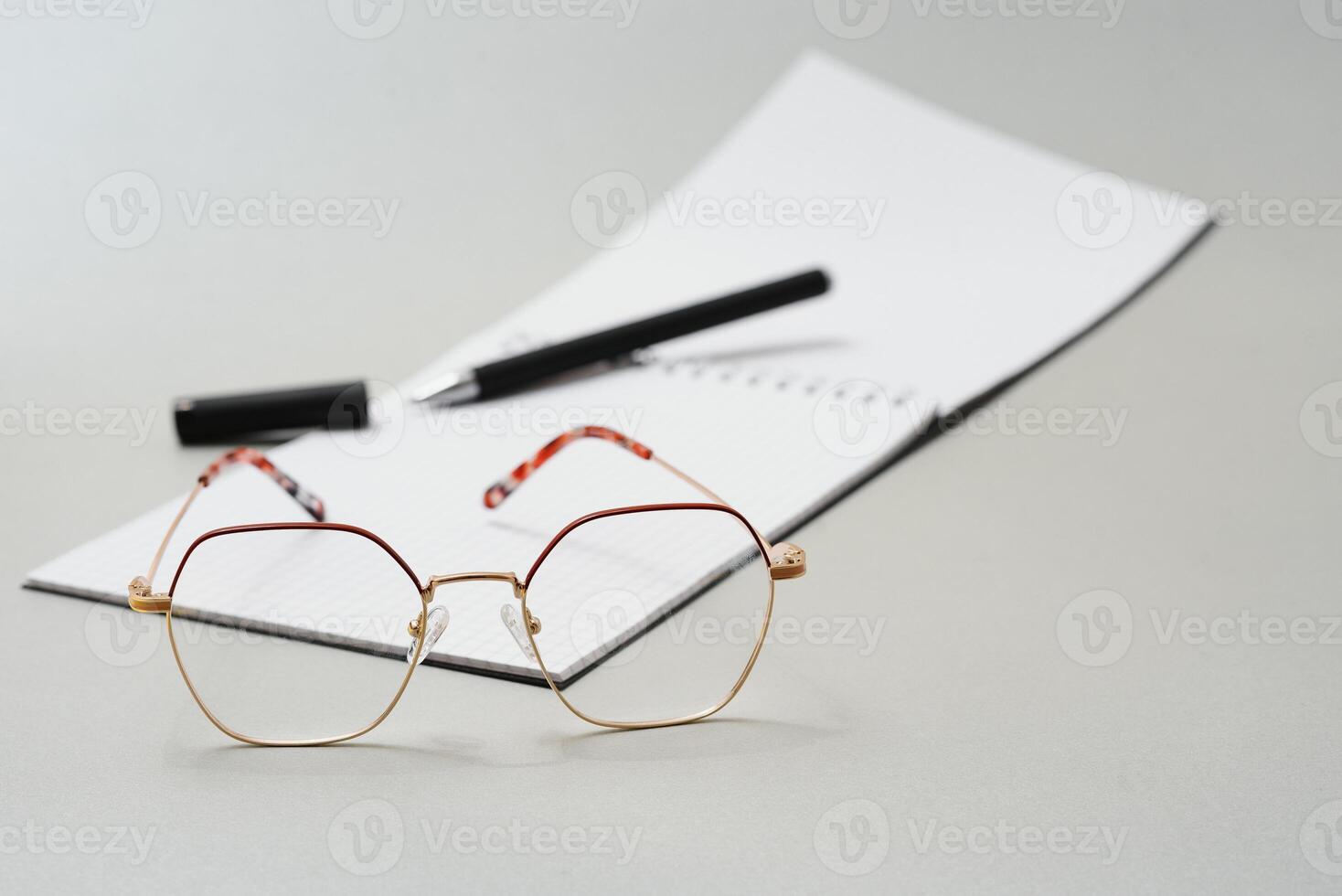 Blank diary, pen, and glasses on white background photo