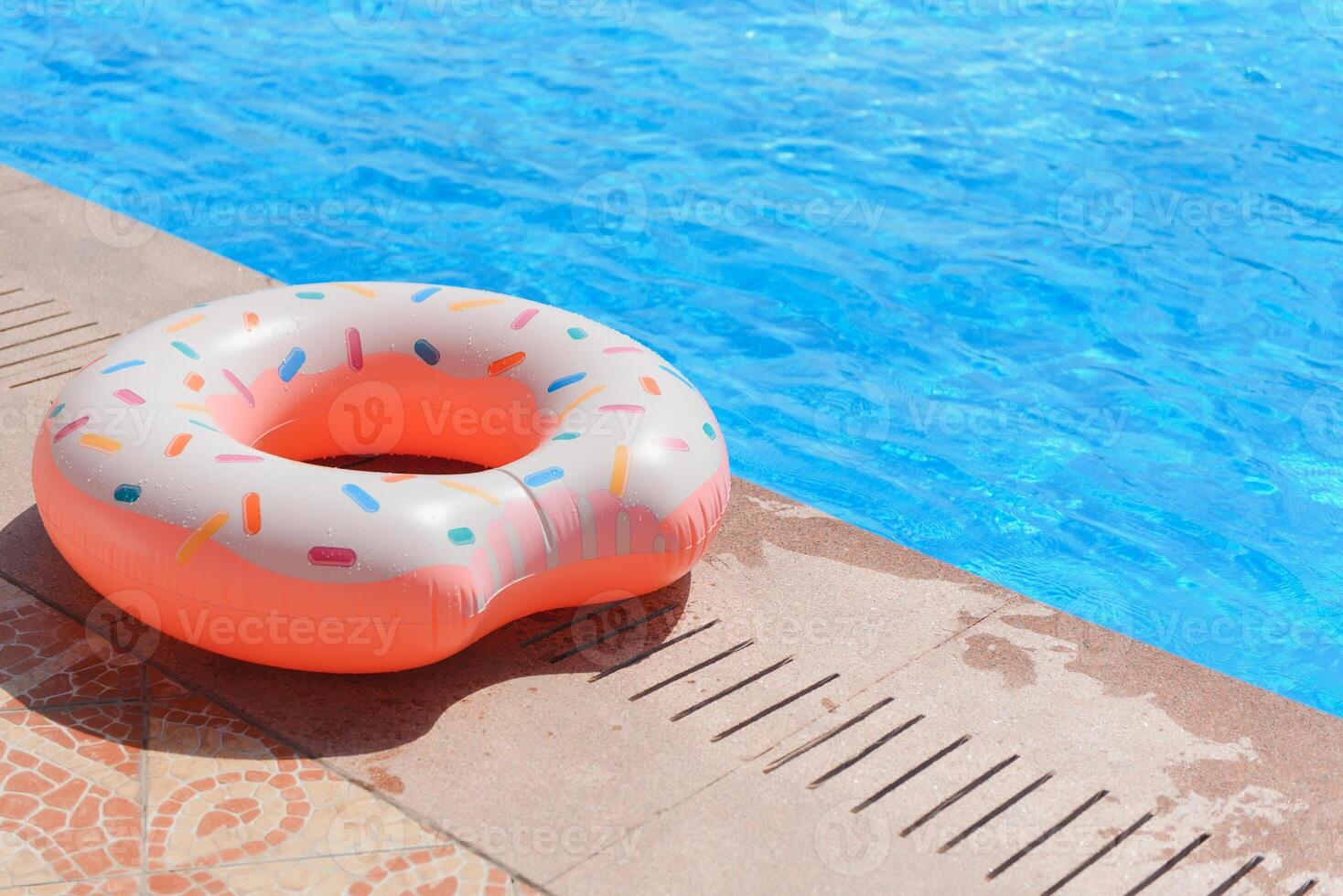 Inflatable swim ring in shape of donut floating in pool photo