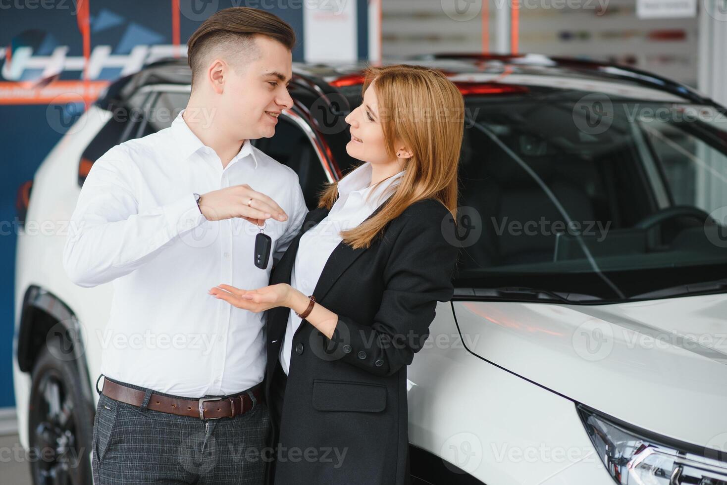 joven hermosa contento Pareja comprando un coche. marido comprando coche para su esposa en un salón. coche compras concepto foto