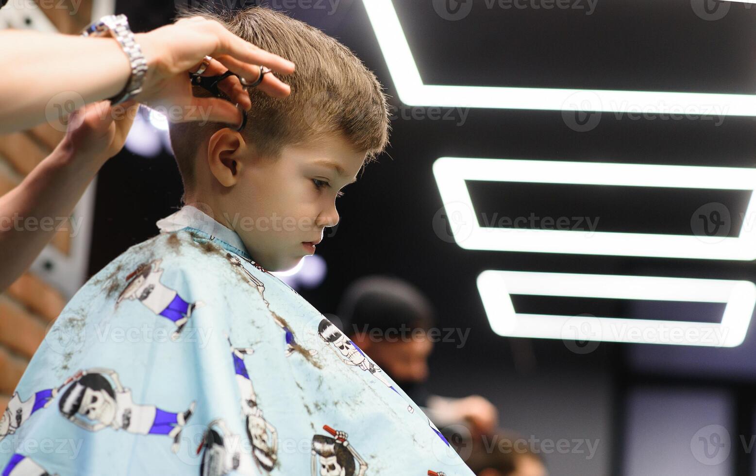 alegre caucásico chico consiguiendo peinado en barbería foto