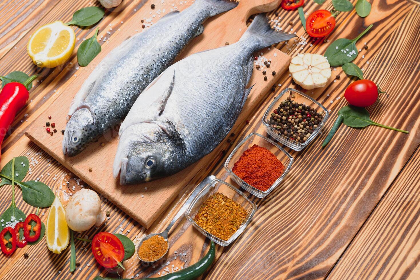 crudo pescado Cocinando y ingredientes. dorado, limón, hierbas y especias parte superior ver con Copiar espacio en mesa foto