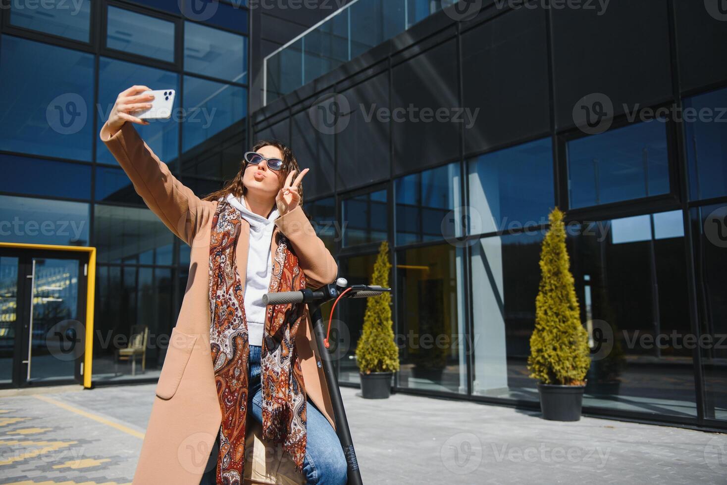 Young beautiful woman riding an electric scooter to work, modern girl, new generation, electric transport, ecology, ecological transport, sunset, electric skateboard. photo