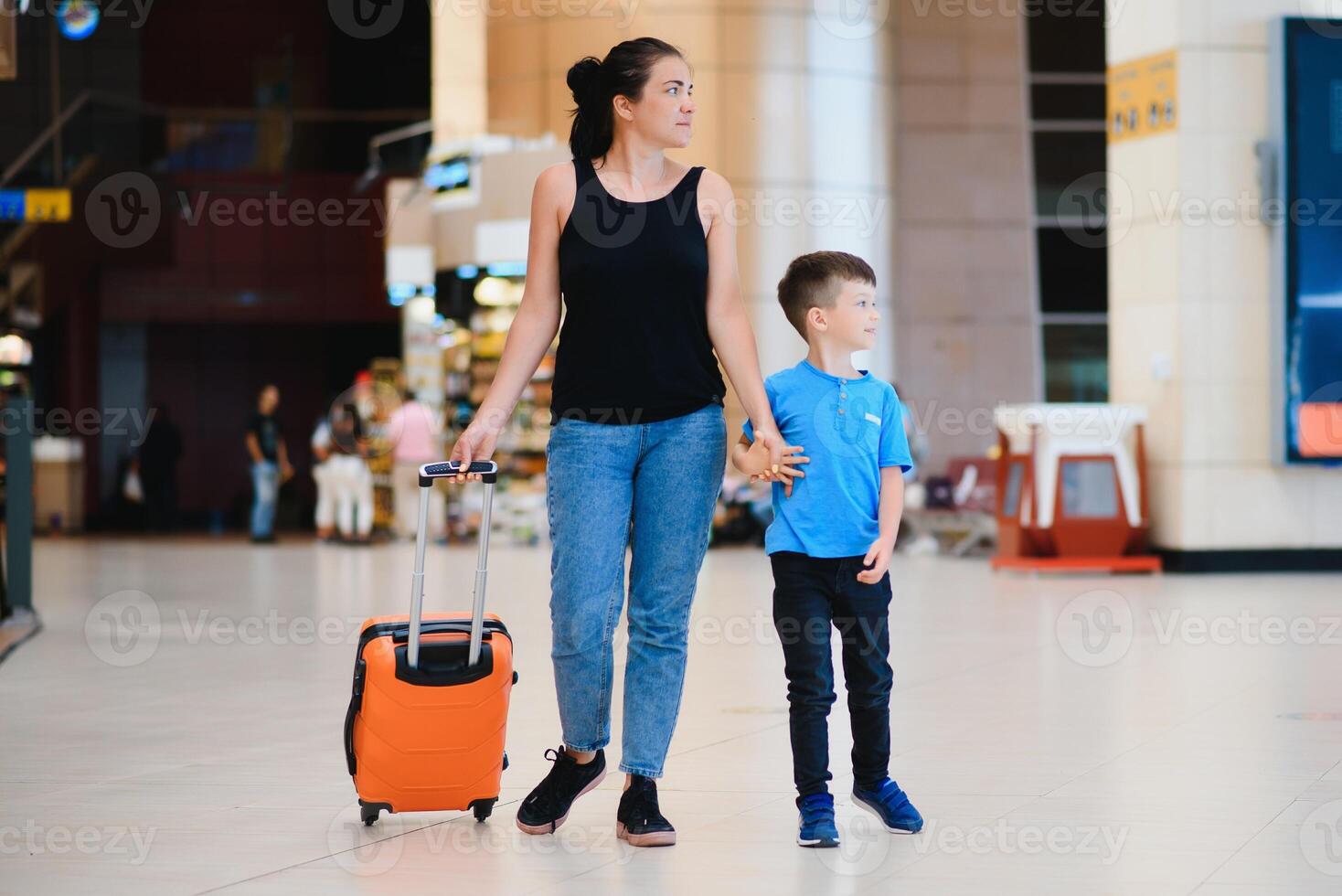 Woman and her child passing through the airport terminal photo