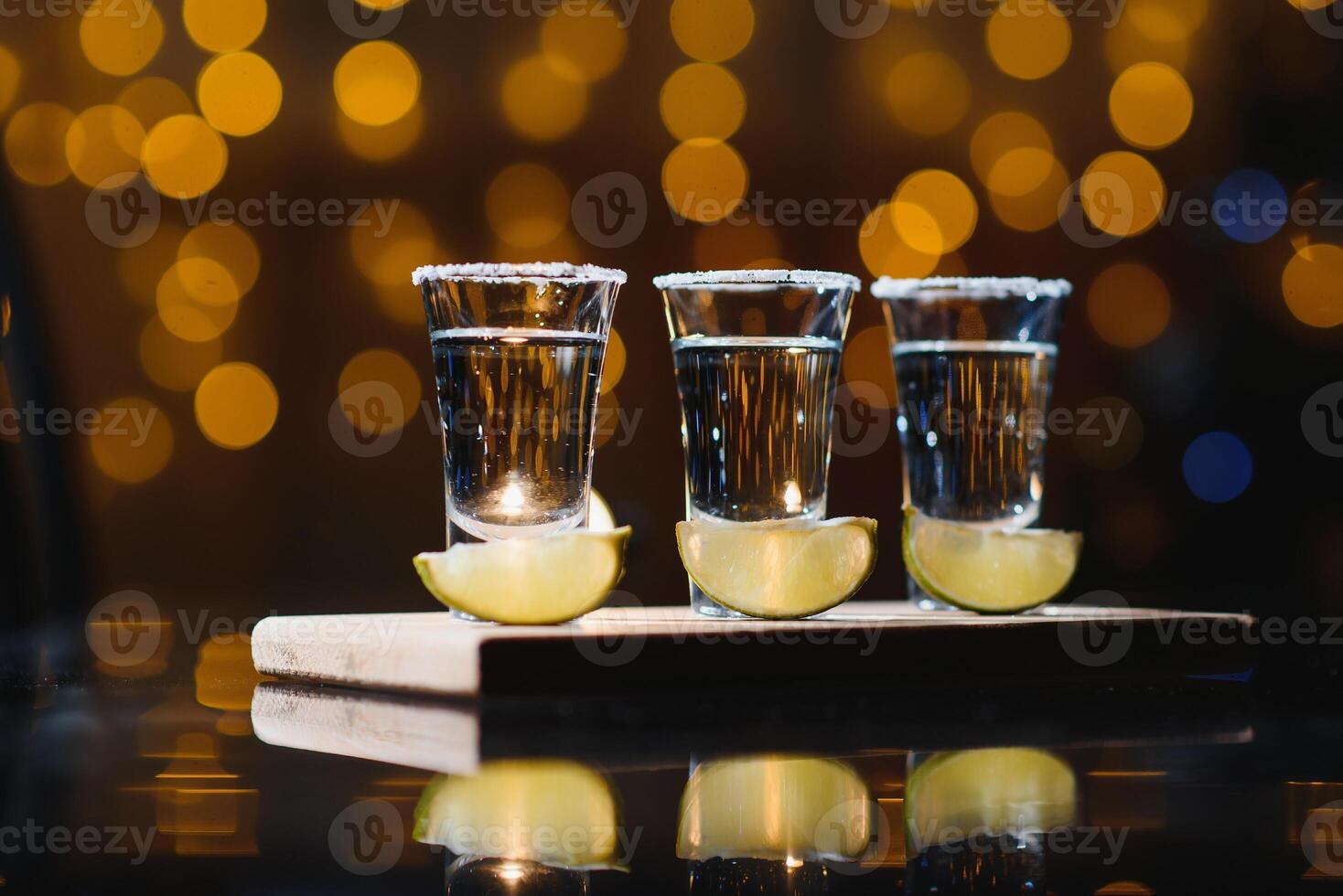 Mexican Tequila with lime and salt on wooden table, selective focus. Copyspace. photo