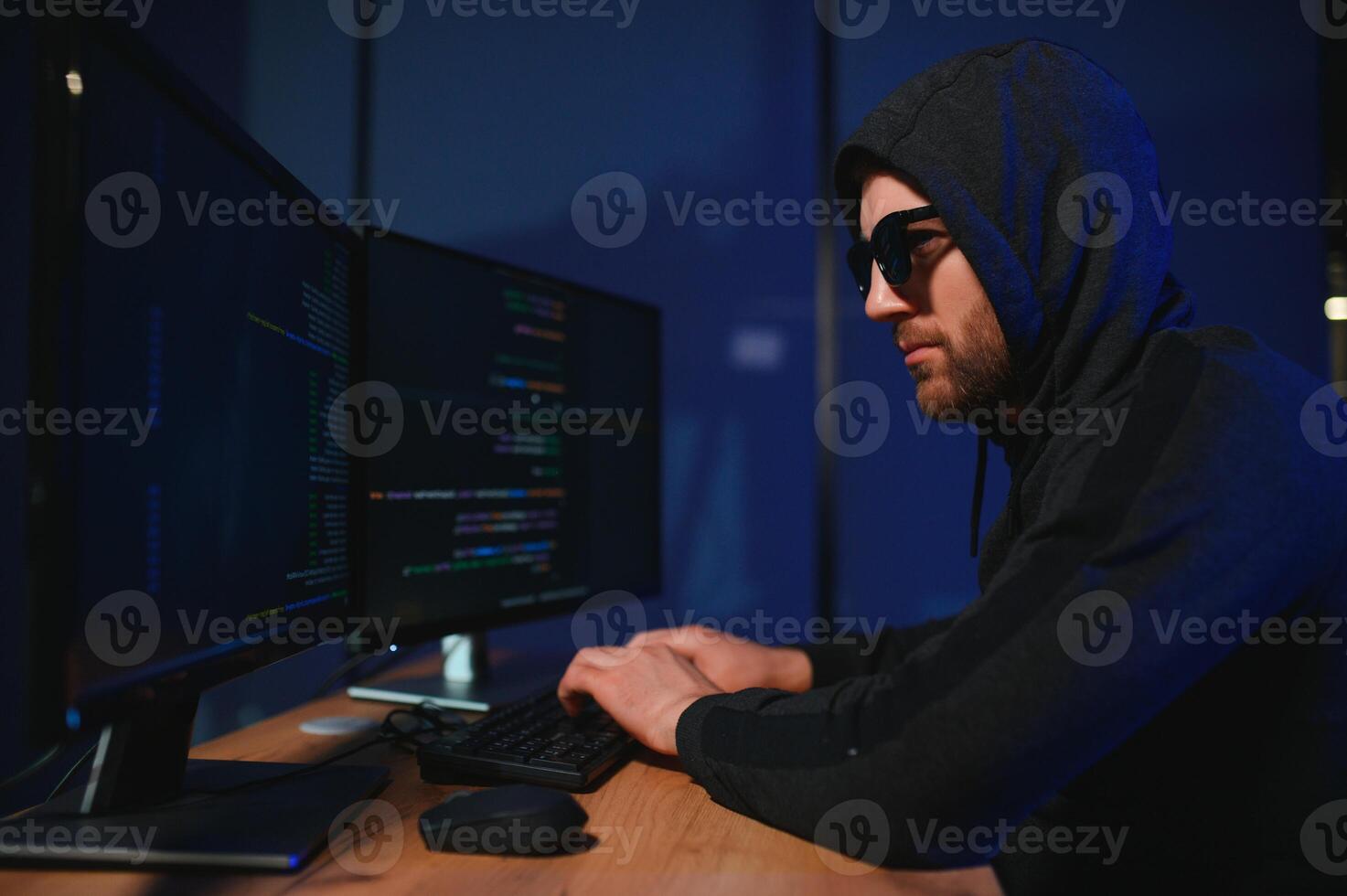 hacker sentado a escritorio en oscuro atmósfera. un computadora programador o hacker anónimo computadora hacker foto