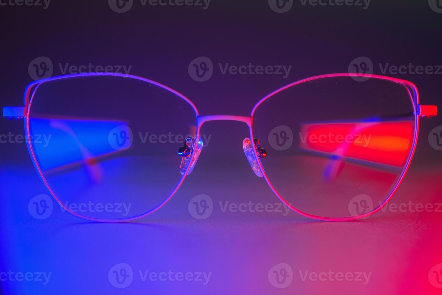 Stylish glasses shot using pink and blue abstract colored lighting with copy space. photo