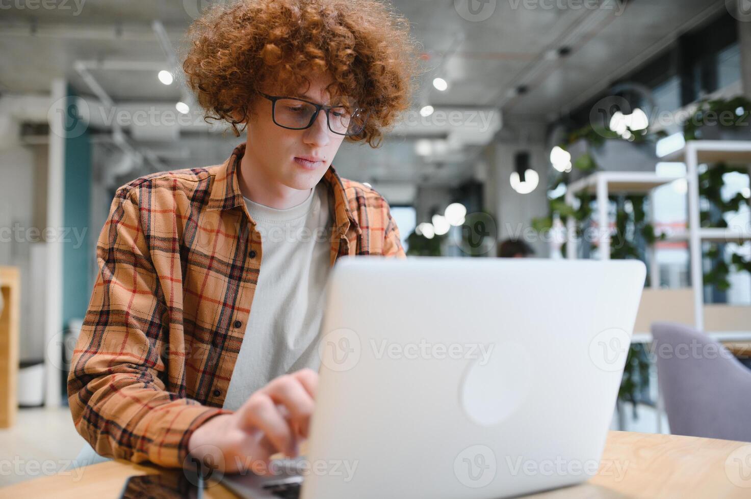 masculino programador vestir gafas para ojos proteccion mientras trabajando en Lanza libre vía ordenador portátil computadora, inteligente estudiante acecho tutorial en netbook foto