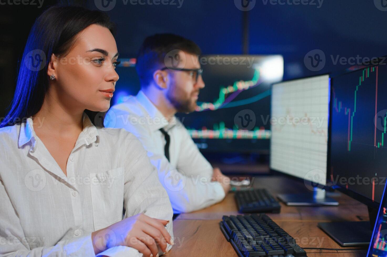 Team of traders working at monitor computer and browsing online in trading office photo