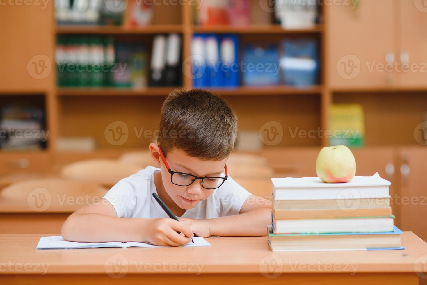 Little child writing with colorful pencils, indoors. Elementary school and education. Kid learning writing letters and numbers. photo