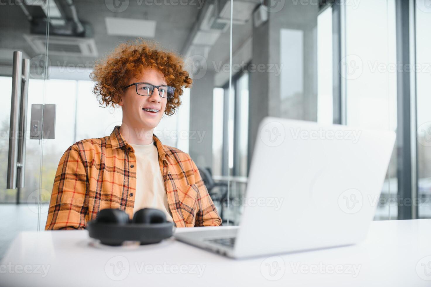 male programmer wear spectacles for eyes protection while working on freelance via laptop computer,clever student watching tutorial on netbook. photo