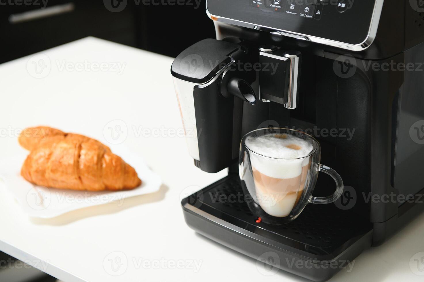 Modern coffee machine on table in kitchen photo