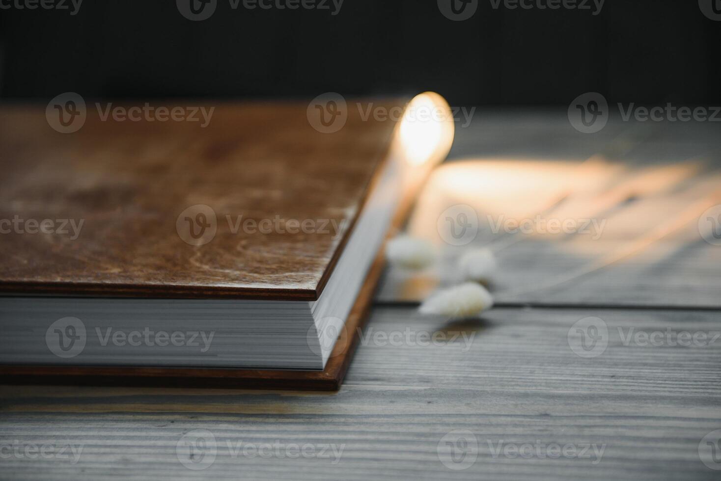 Family photo book with embossing. Photo book on a wooden background. Brown photo book with wood cover. Photoalbum with a hard cover. Wedding photo album.