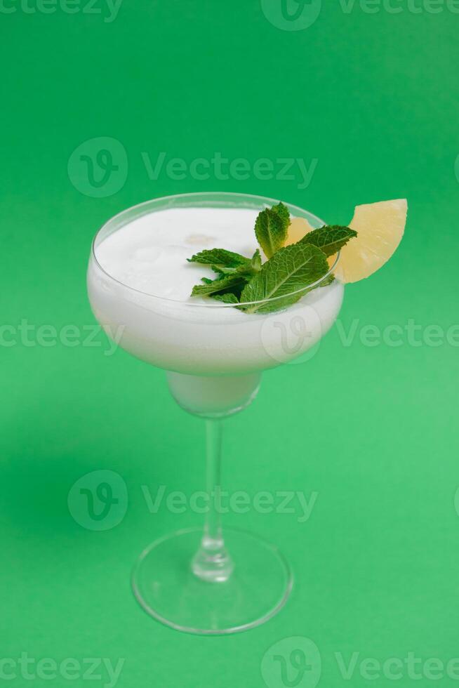 Pina Colada in front of green background. photo