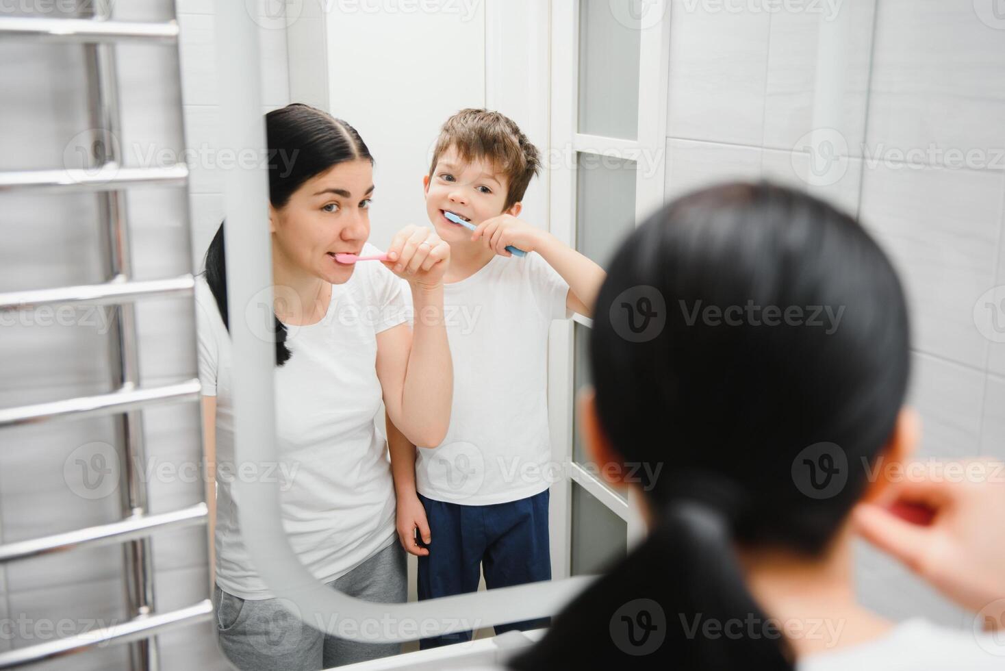 cute mother teaching kid boy teeth brushing photo