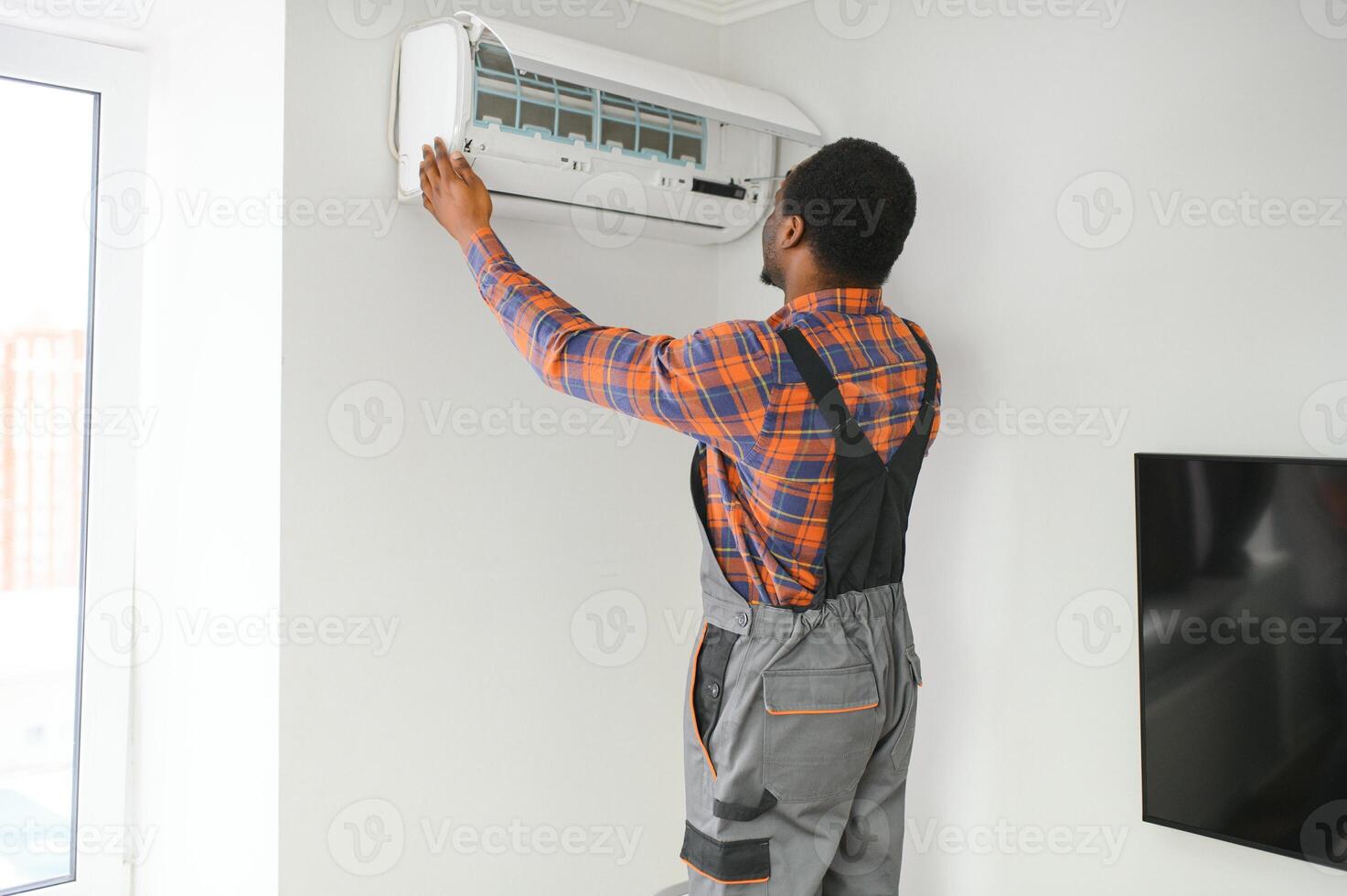 Professional repairman installing air conditioner in a room photo