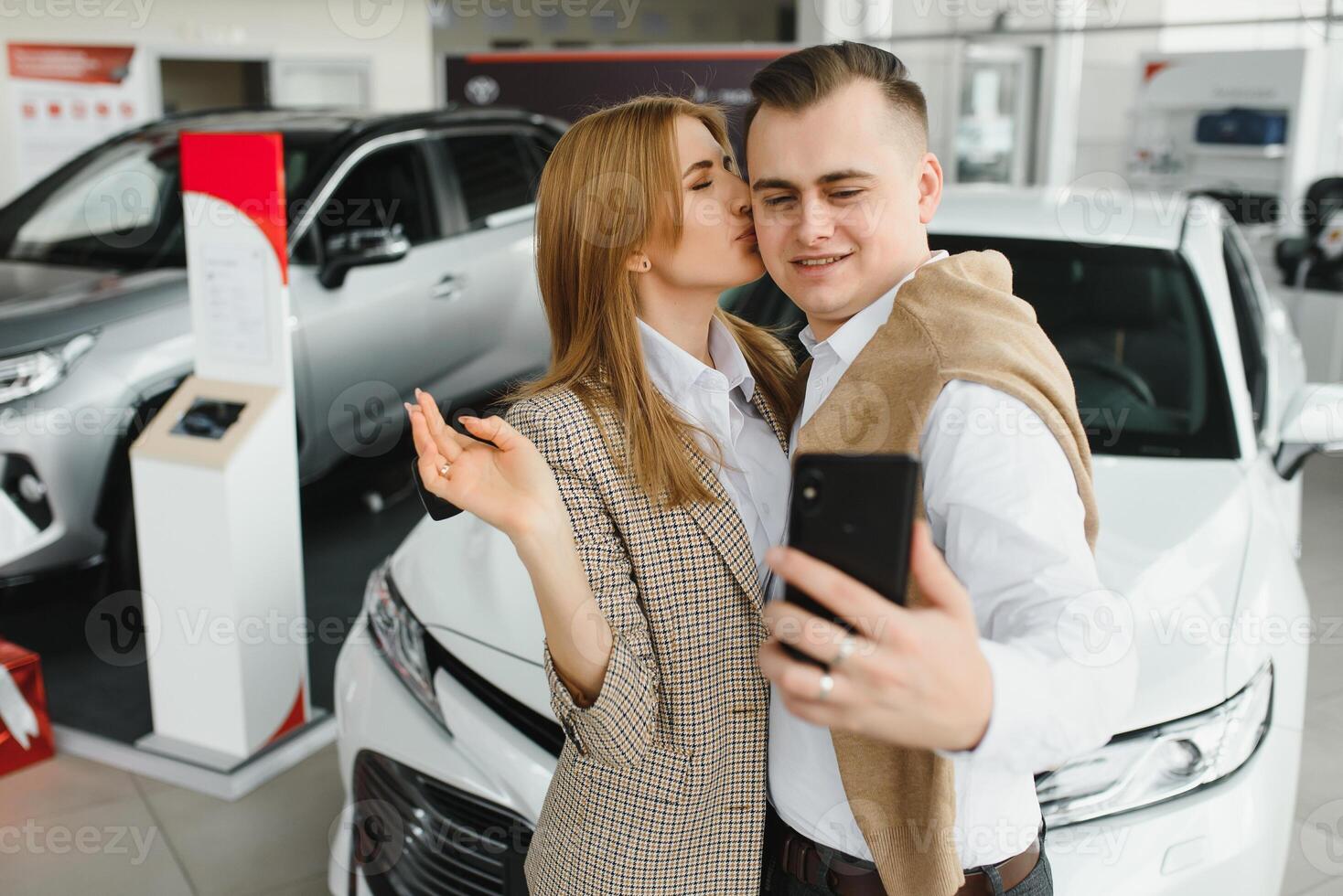 joven Pareja comprando un coche en un coche sala de exposición. foto