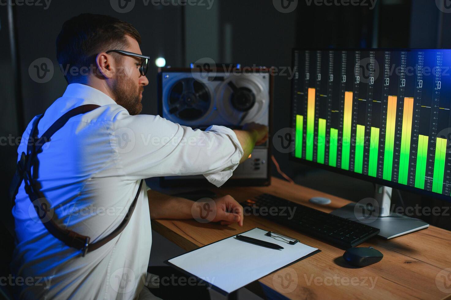 A male spy listens and records conversations on a reel-to-reel tape recorder photo