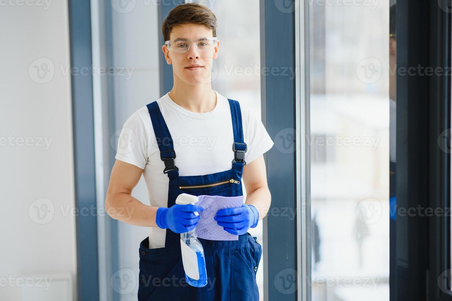 Handyman cleaning the window and smiling in a new house photo