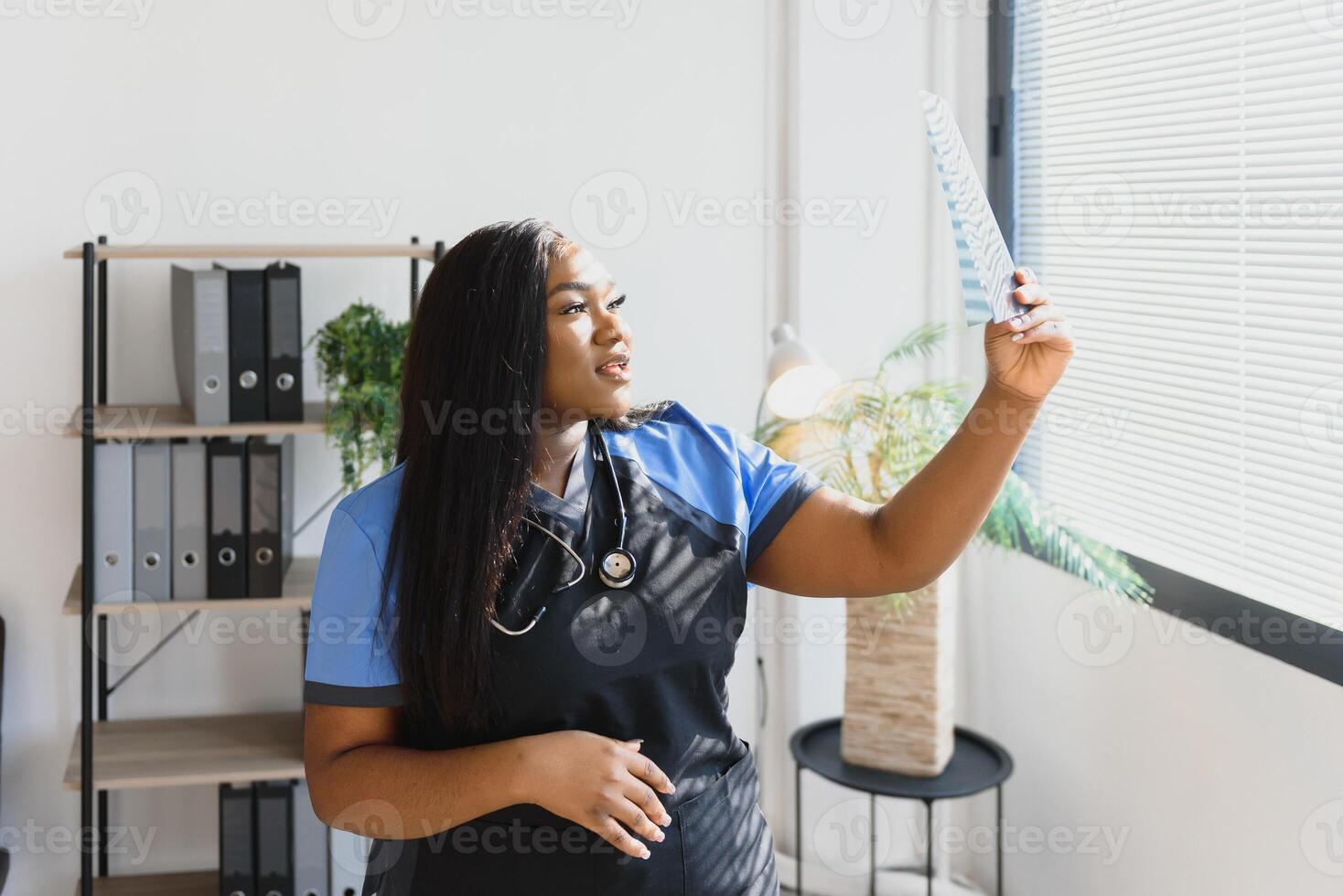 beautiful female african medical worker holding x-ray. photo
