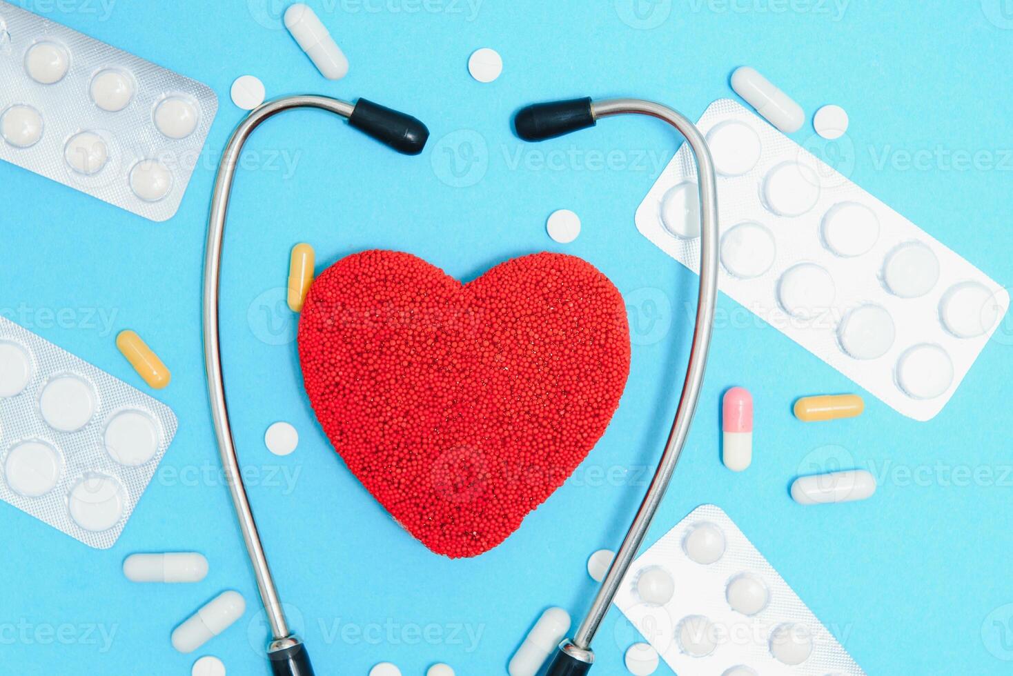 Global healthcare concept.Stylish doctor with heart on blue background.Close-up of red heart and stethoscope on a blue background. Listen to the heart with statoscope photo