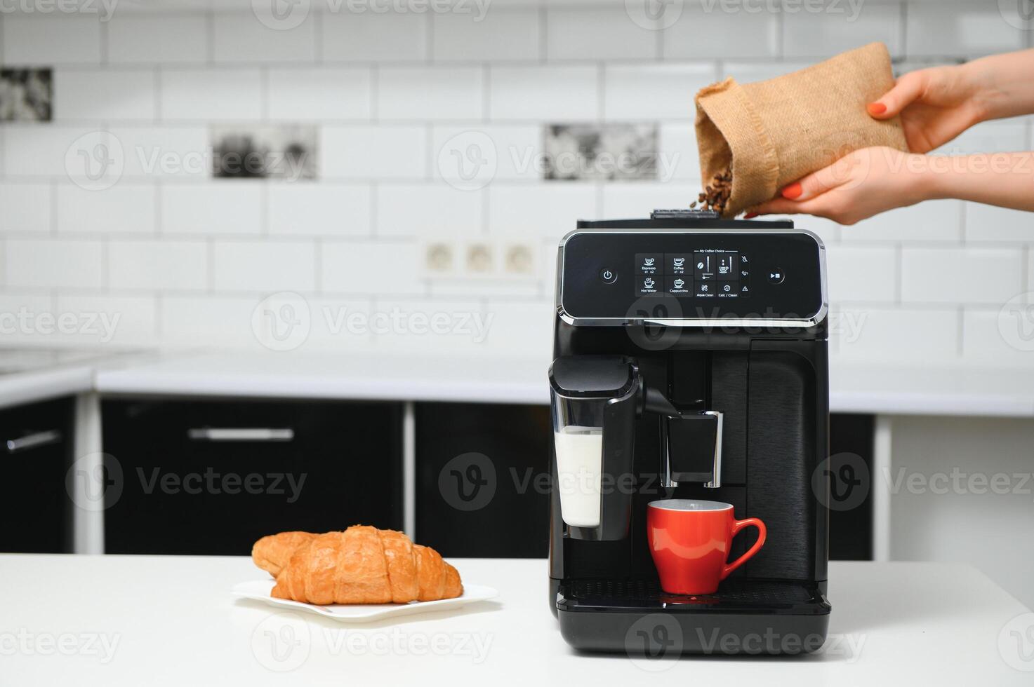 blurred background of kitchen and coffee machine with red cup and space for you photo