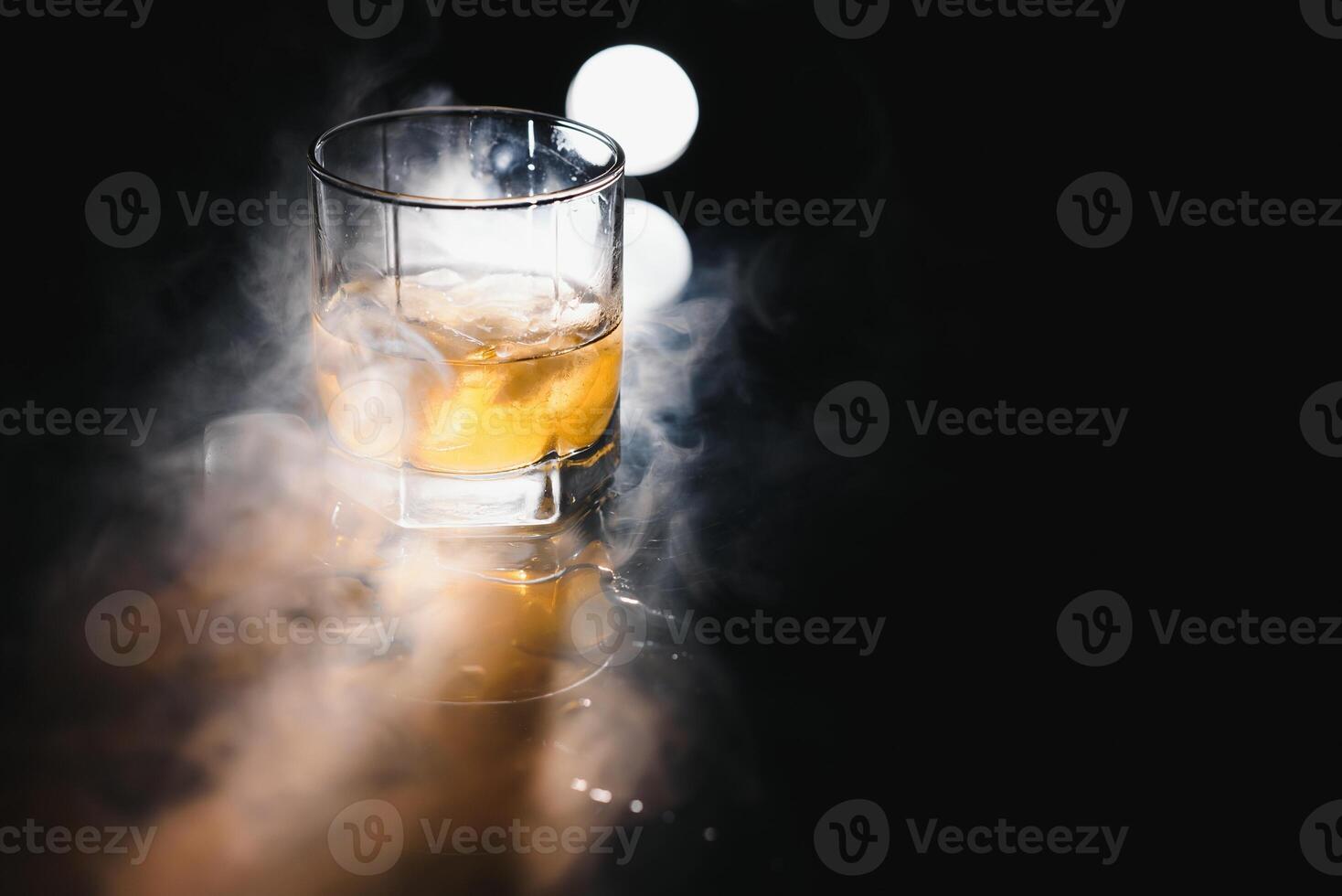 Glass of scotch whiskey and ice photo