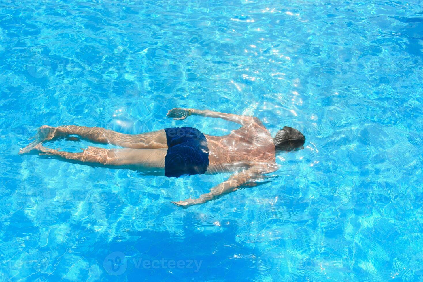 Young athletic man swimming in the swimming pool. Active sport photo