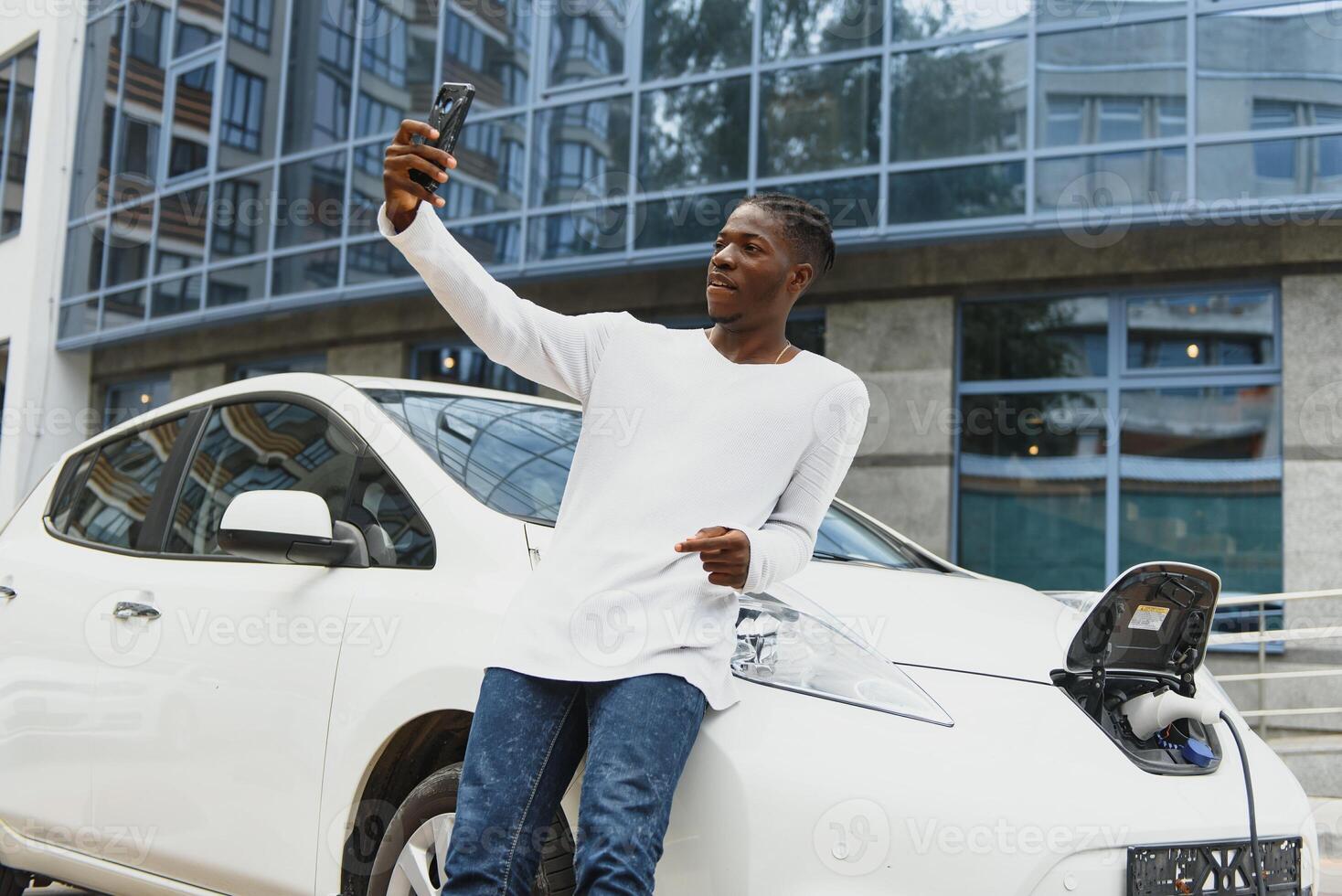 africano americano hombre cargando su eléctrico coche. foto