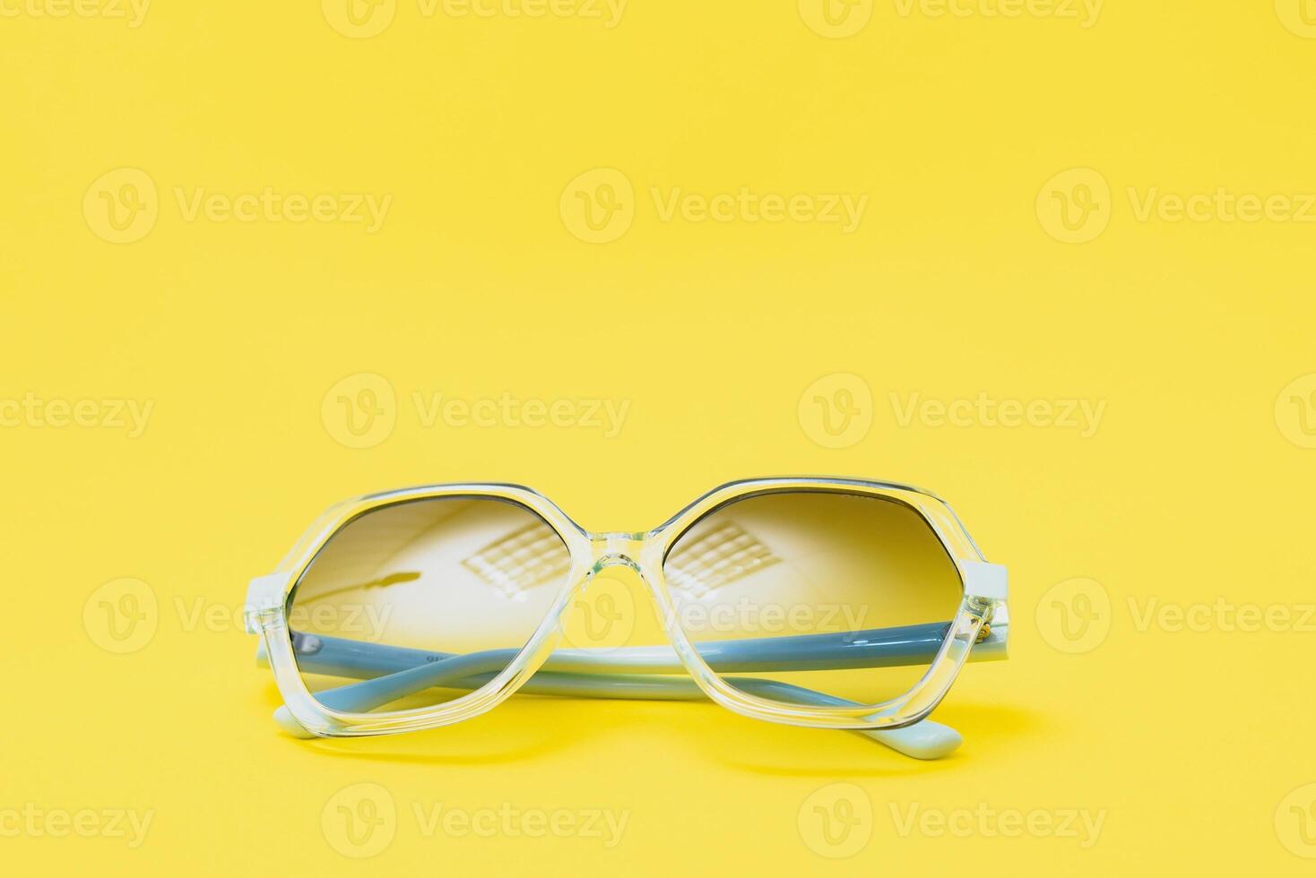 yellow sunglasses on yellow background photo