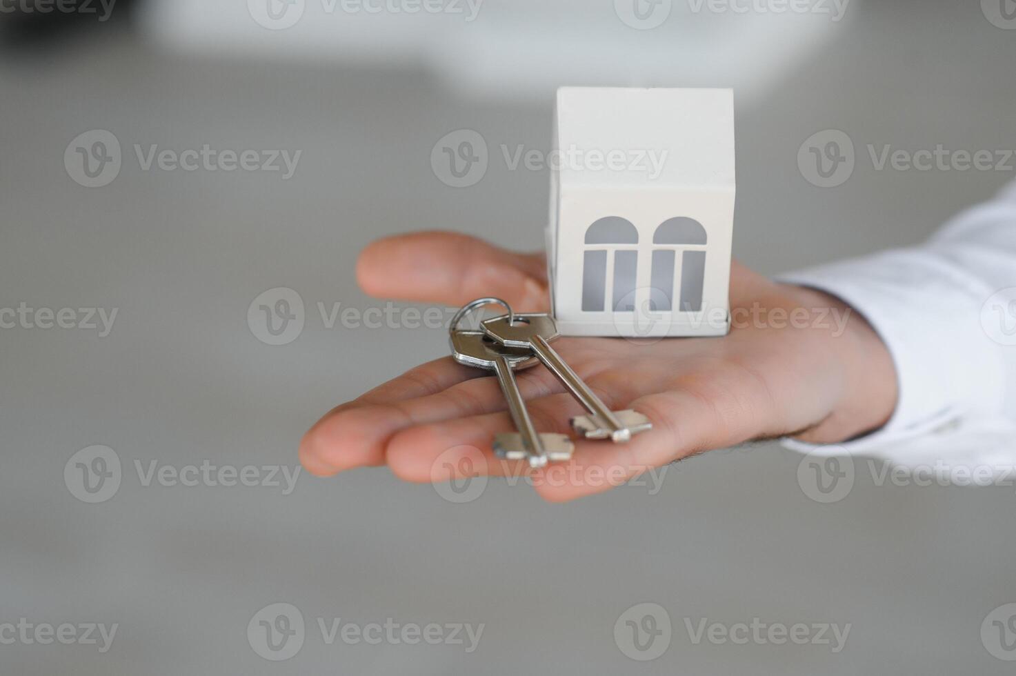 Real estate agent with house model and keys photo