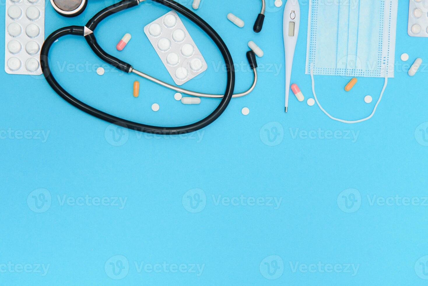 Flat lay aerial of accessories healthcare and medical background concept.Table top view stethoscope on blue paper and objects photo