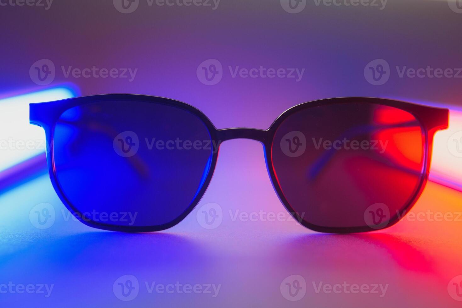 Stylish sunglasses shot using pink and blue abstract colored lighting with copy space. photo