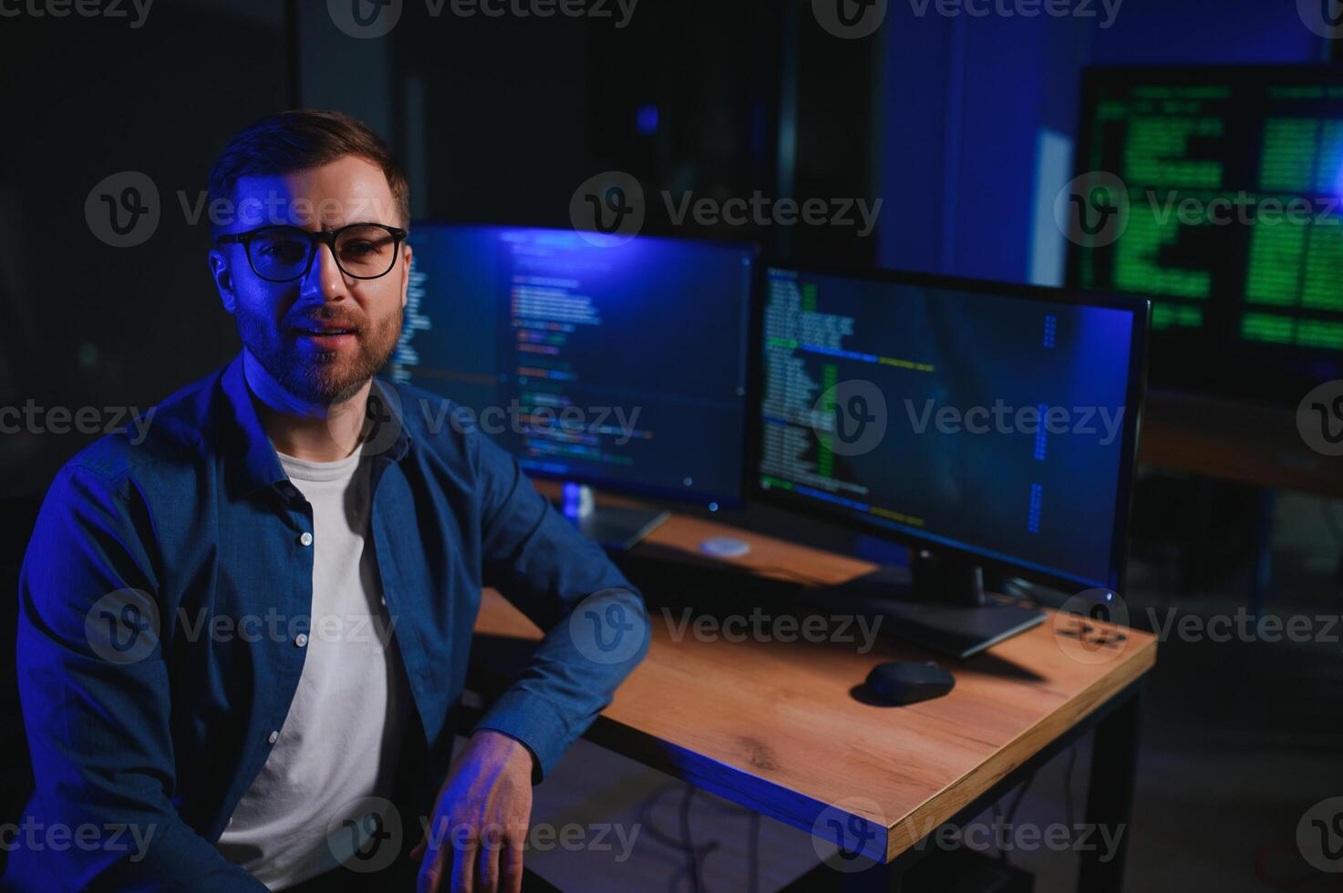 Male programmer working on desktop computer at white desk in office photo