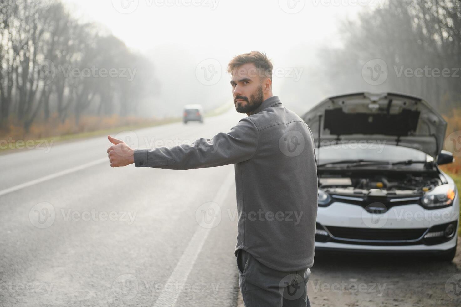 triste conductor teniendo motor problema en pie cerca roto coche en el la carretera. coche Descompostura concepto foto