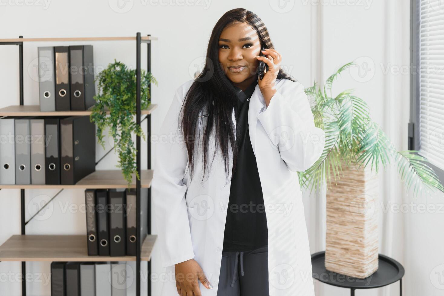 Smiling female doctor using mobile phone in the hospital photo