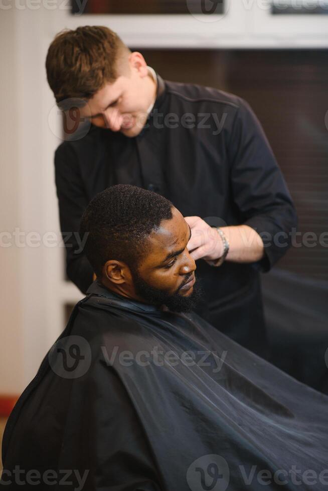 joven afroamericano hombre visitando barbería foto