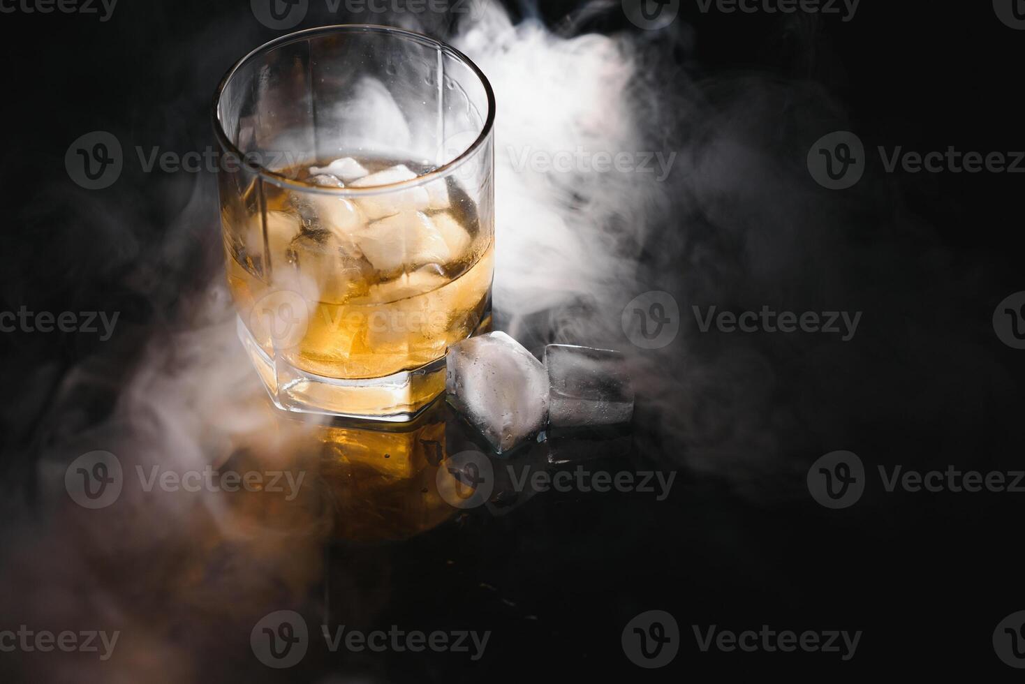 Whiskey glass black background shiny photo