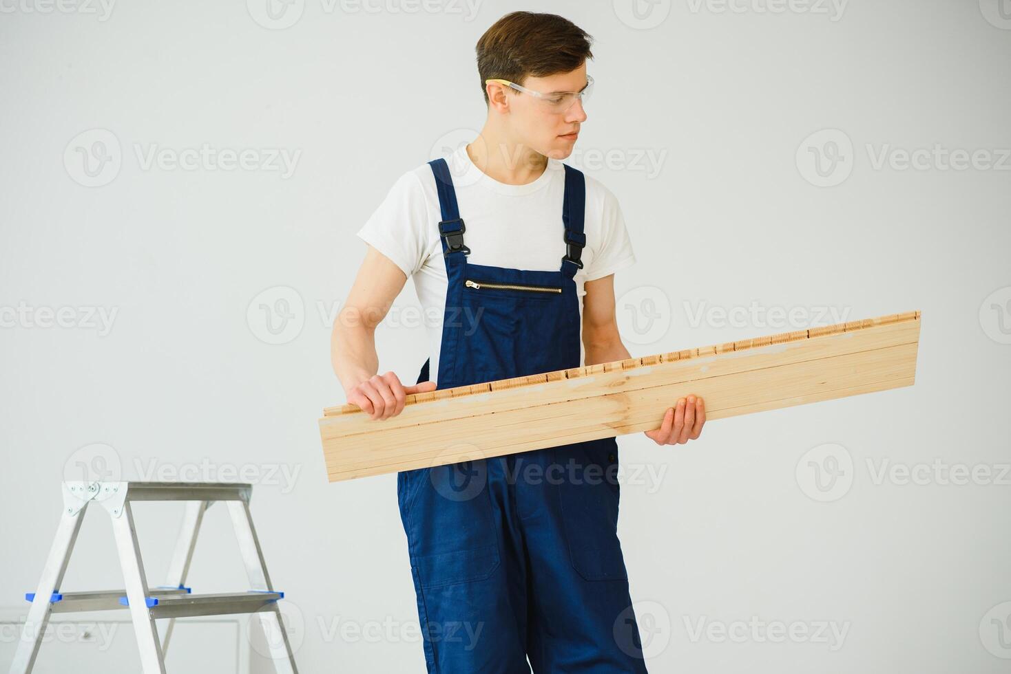 Worker with materials for installing laminate flooring photo