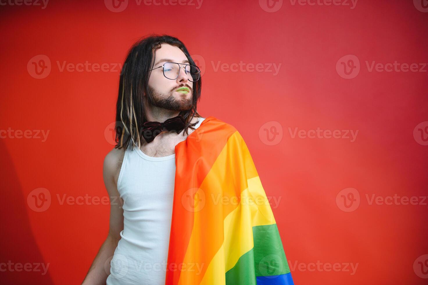 Young gay man is standing in the studio and posing for a camera. photo