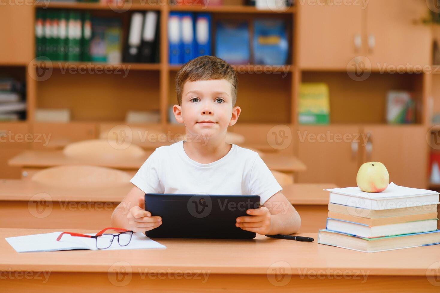 school boy using tablet compute in classroom photo