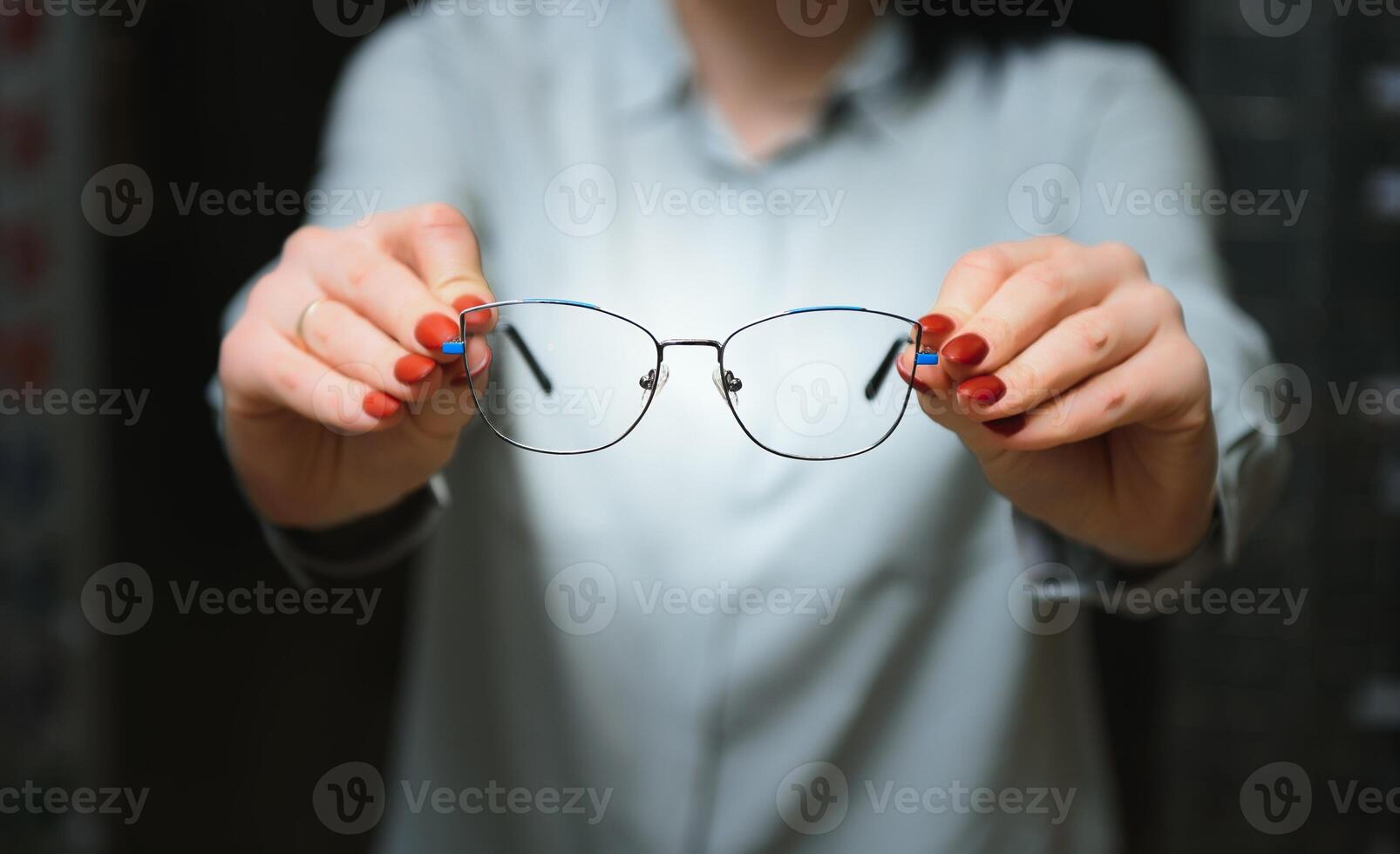 Closeup of optometrist, optician giving glasses to try. photo